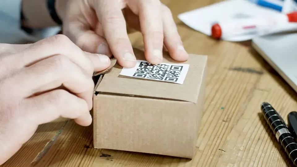 Hands holding a cardboard product box on a table, a simple product photo setup