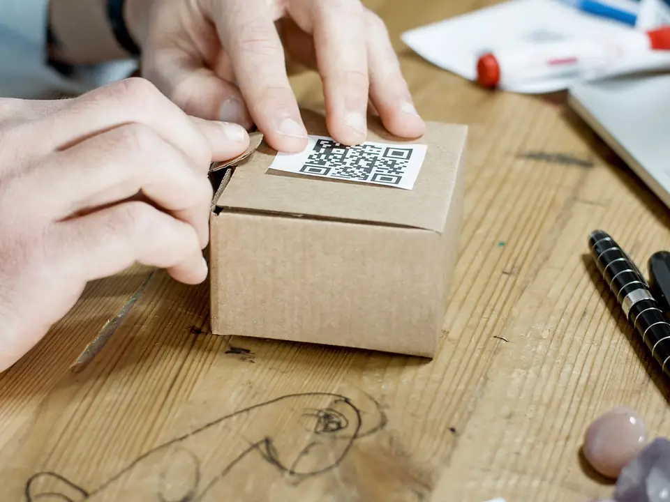 Hands sealing a small parcel for an online order, the sale a Shopping or Performance Max campaign is built to bring