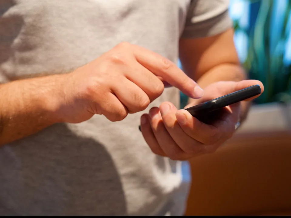 Hands tapping a smartphone screen, as when someone submits a Facebook instant form or a salesperson calls a new lead back