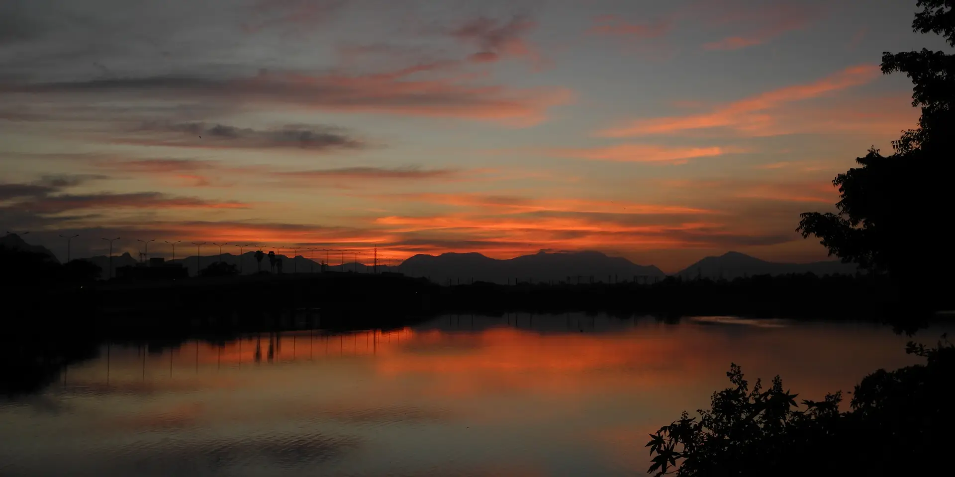Sunset over Valankulam Lake in Coimbatore, Tamil Nadu, with hills on the horizon